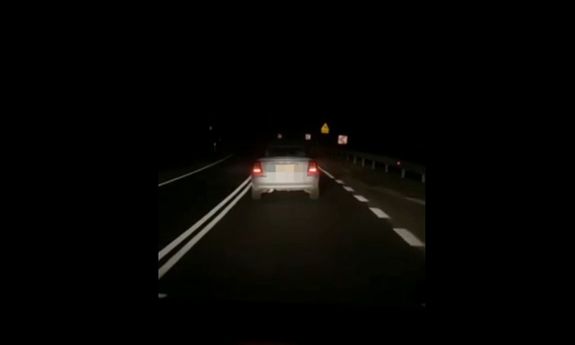 pora nocna . Jadące po jezdni auto - widok z tyłu