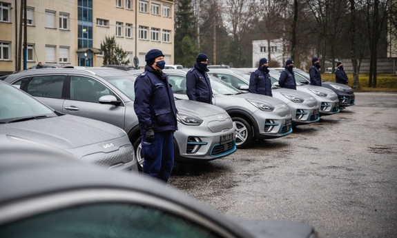 umundurowani policjanci stoją przy samochodach elektrycznych