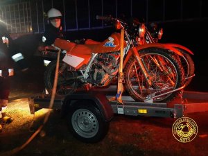 strażak zdejmuje motocykle z przyczepy