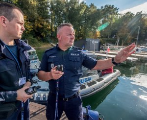 dwóch umundurowanych policjantów stoi na pomoście