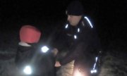 Policjant zapina kurtkę policyjną, w którą ubrał chłopca