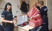 funkcjonariusze pakują paczki świąteczne w ozdobny papier