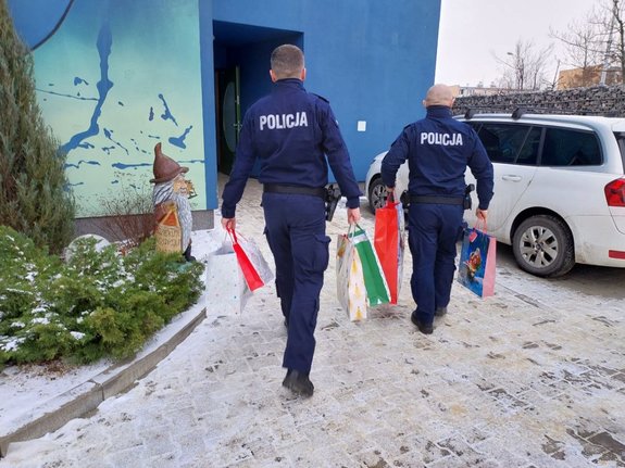 umundurowani policjanci wnoszą prezenty do hospicjum