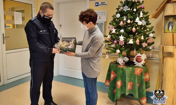 policjant przekazuje dary przedstawicielce hospicjum