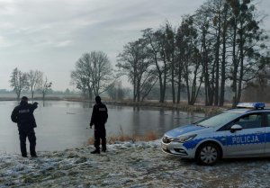 dwaj policjanci przy brzegu zbiornika wodnego