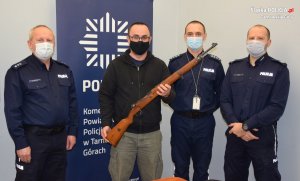 trzej policjanci i dyrektor muzeum, który trzyma w ręku przekazanego mausera