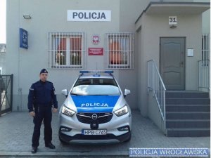 policjant przy radiowozie przed Posterunkiem Policji w Żórawinie