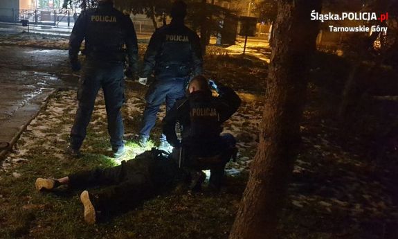 Na zdjęciu widać policjantów oraz leżącego na ziemi, obezwładnionego włamywacza