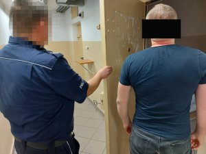 policjant z zatrzymanym mężczyzną