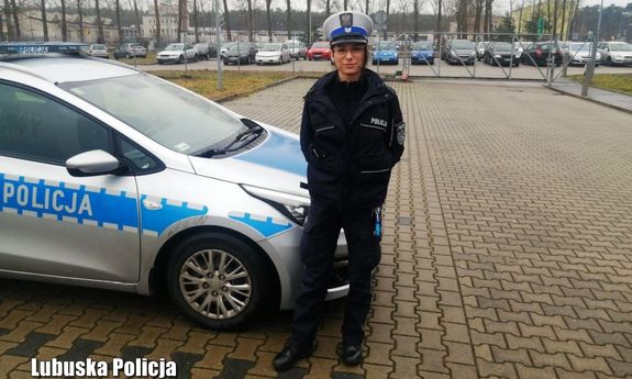 Policjantka na parkingu na tle radiowozu