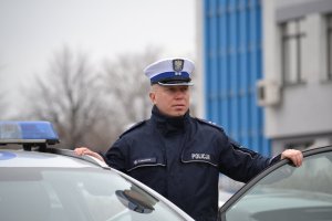 policjant stoi przy radiowozie