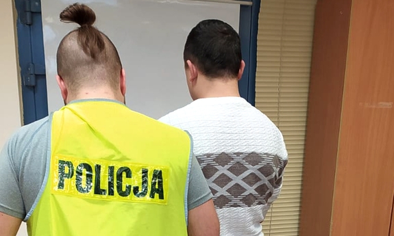 policjant stoi z zatrzymanym mężczyzną