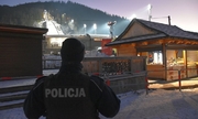 umundurowany policjant na tle skoczni narciarskiej