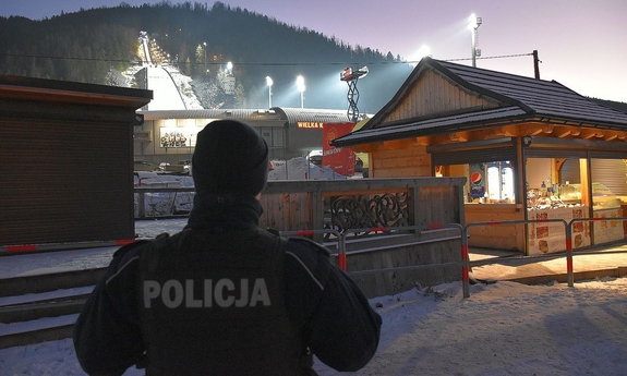 umundurowany policjant na tle skoczni narciarskiej