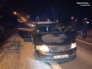 Zdjęcie samochodu audi, w tle policjanci