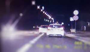 zdjęcie samochodu z wideorejestratora, na którym widać, że biały samochód wyprzedza na przejściu dla pieszych