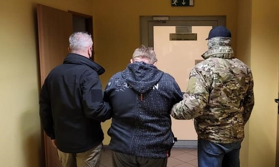 dwaj nieumundurowani policjanci z zatrzymanym mężczyzną