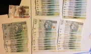 banknoty w kwocie nominale 100 złotych i 10 złotych rozłożone leżą na stole