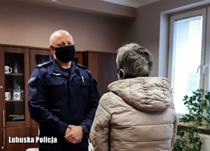Policjant rozmawia ze starszą kobieta w pomieszczeniu