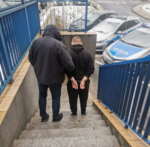 policjant z zatrzymanym na schodach