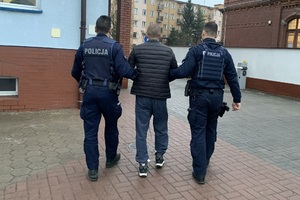 umundurowani policjanci prowadzą zatrzymanego mężczyznę