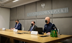 Mariusz Kamiński Minister Spraw Wewnętrznych i Administracji, Maciej Wąsik Sekretarz Stanu, Komendant Główny Policji gen . insp. Jarosław Szymczyk siedzą przy stole konferencyjnym podczas odprawy