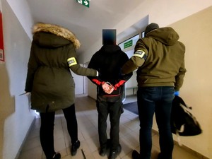 Zatrzymany prowadzony przez nieumundurowanych policjantów