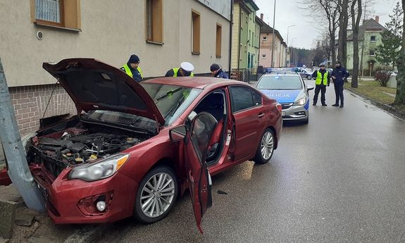 policjanci stoją przy rozbitym samochodzie