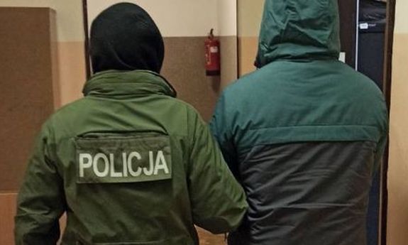 policjant prowadzi zatrzymanego