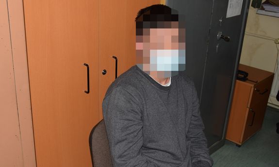 zatrzymany mężczyzna siedzi na krześle podczas przesłuchania