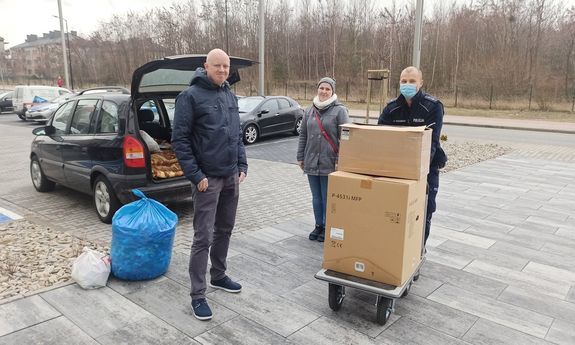 policjant, radny przekazują nakrętki mamie chorej dziewczynki