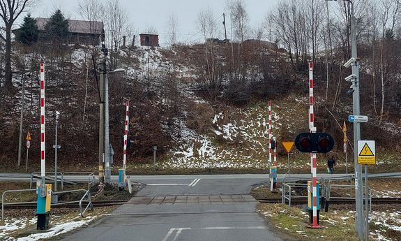 przejazd kolejowy z podniesionymi rogatkami