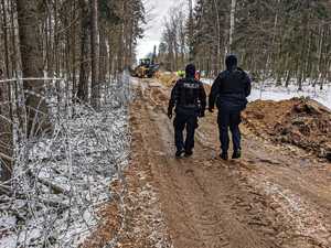 umundurowani policjanci zabezpieczają budowę zapory na granicy z Białorusią, patrolują i obserwują rejon oraz dbają o bezpieczeństwo osób wykonujących prace budowlane na granicy.