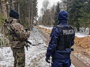 umundurowani policjanci zabezpieczają budowę zapory na granicy z Białorusią, patrolują i obserwują rejon oraz dbają o bezpieczeństwo osób wykonujących prace budowlane na granicy.