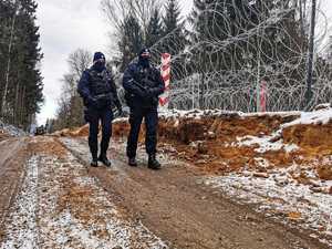 umundurowani policjanci zabezpieczają budowę zapory na granicy z Białorusią, patrolują i obserwują rejon oraz dbają o bezpieczeństwo osób wykonujących prace budowlane na granicy.