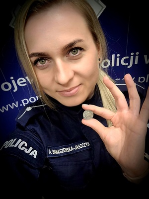 umundurowana policjantka trzymając w dłoni przypinkę dawcy przeszczepu