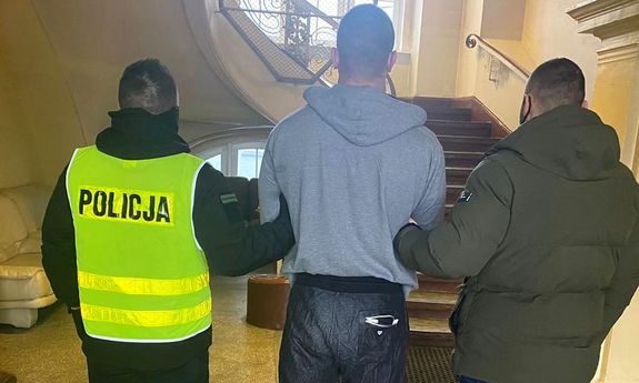 dwaj policjanci prowadzą zatrzymanego za rozbój