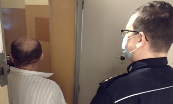 policjant z zatrzymanym mężczyzną