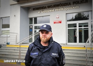 Umundurowany policjant przed budynkiem komendy Policji