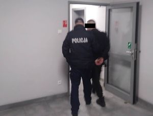 policjant prowadzi zatrzymanego mężczyznę