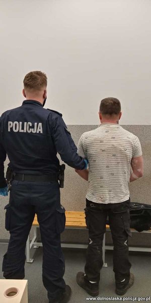 policjant z zatrzymanym stojący tyłem