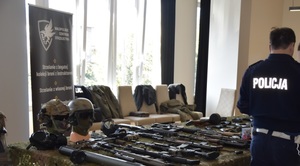wystawa broni, umundurowany policjant oraz uczestnicy biorący udział w akcji charytatywnej