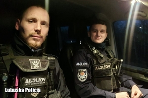 dwaj umundurowani policjanci siedzą w radiowozie