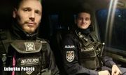 dwaj umundurowani policjanci siedzą w radiowozie