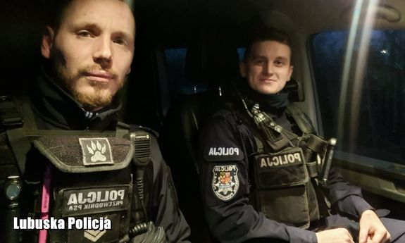 dwaj umundurowani policjanci siedzą w radiowozie