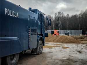 po lewej stronie pojazd służbowy tajfun, w oddali budowa zapory granicznej