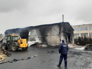 policjant stoi naprzeciwko spalonej hali