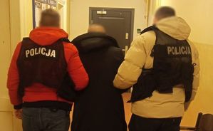 policjanci prowadzą zatrzymanego mężczyznę