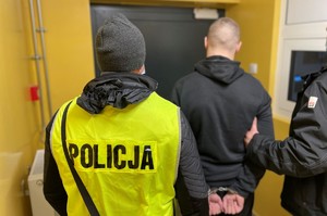 dwa policjanci prowadzą zatrzymanego