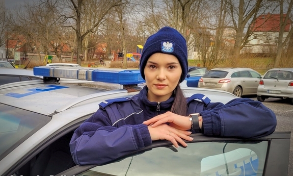 policjantka w mundurze przy radiowozie